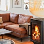 Ein Wohnzimmer mit einem Ledersofa, einem Kamin und einem Tisch mit Tassen.