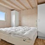 Schlafzimmer mit Holzwänden, Bett und Fenster