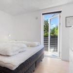 Schlafzimmer mit Bett, Schrank und Tür zum Balkon.