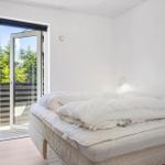 Schlafzimmer mit Bett, Schrank und Glastür zum Balkon.