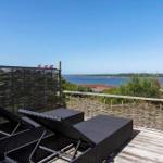 Terrasse mit Liegen und Blick aufs Wasser und Flaggen.