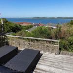 Terrasse mit Liegen und Blick auf See und Flaggen.