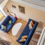 Zwei blaue Sofas mit Kissen, weißer Tisch und Holzboden im Wohnbereich.
