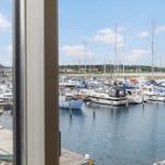 Von einem Fenster aus sieht man einen Hafen mit vielen Booten und Yachten.