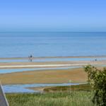 Meeresblick mit Strand und zwei Personen im Wasser