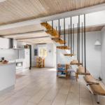 Küche mit Essbereich und Holztreppe zur oberen Etage.