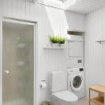 Bathroom with shower, toilet, washing machine, and dryer.