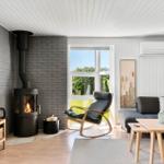 Living room with fireplace, sofa, chair, and window to the garden.