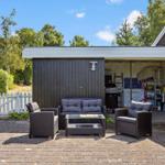Außenbereich mit Sitzgruppe unter Pavillon. Garage und Gartenbereich sichtbar.