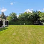 Großer grüner Garten mit Fußballtor, Schaukel und Spielplatz. Hinterhof mit Pavillon und Sitzgelegenheiten.