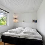 Schlafzimmer mit Doppelbett, Fenster und Regal