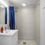 Badezimmer mit Dusche, Waschbecken und Spiegel