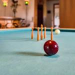 Billiard table with balls and bowling pins on green felt