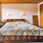 Bedroom with bed, nightstand, wall lamps, and window