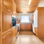 Kitchen with wooden cabinets, refrigerator, and window