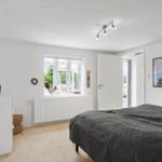 Schlafzimmer mit Bett, Fenster und Wandbild.