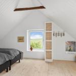 Schlafzimmer mit Dachschräge, Fenster und Holzboden