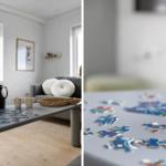 Ein Wohnzimmer mit einem Tisch, auf dem Puzzleteile liegen, und einem Sofa mit Kissen.
