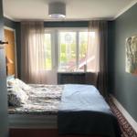 Schlafzimmer mit Bett, Fenster und Wandbild.
