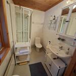 Badezimmer mit Dusche, Toilette, Waschbecken und Spiegel.