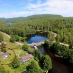 Haus mit Grillplatz neben Fluss und Wald. Aussicht auf See und Berge.