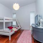 Zimmer mit Doppelbett, Fernseher und Lüfter auf Schrank.