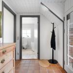 Eingangsbereich mit Schrank, Kleiderständer und Blick in die Toilette.