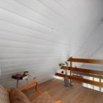 Raum mit Holzdecke, Sessel und Treppe zur Galerie
