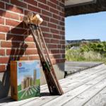 Kubb-Spielzeug auf Terrasse neben Backsteinwand und Dach