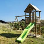 Holzspielplatz mit Rutsche und Schaukel auf grünem Rasen.