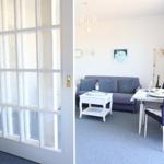 Ein Raum mit Sofa, Esstisch und Fenster mit getöntem Glas.
