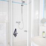 Badezimmer mit Dusche, Waschbecken und Spiegel