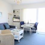Wohnzimmer mit Sofa, Esstisch und TV. Durchgang zur Terrasse.