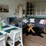 Essbereich mit Tisch und Stühlen, Wohnbereich mit Sofa und Sessel, Holzfußboden und Sauna.
