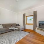 Wohnzimmer mit Sofa, Fernseher und Fenster mit Blick.