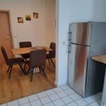 Küche mit Kühlschrank und Essbereich mit Tisch und Stühlen.