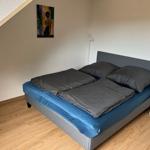 Schlafzimmer mit Doppelbett, Holzboden und Wandbild.