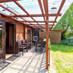 Sonnenterrasse mit direktem Blick in den grünen Garten des Ferienobjekts