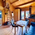 Gemütliches Wohnzimmer im rustikalen Holzblock-Stil des Ferienbungalows Seestern