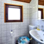 Badezimmer mit Toilette, Waschbecken und Fenster