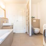 Badezimmer mit Badewanne, Waschmaschine und WC