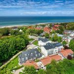 Meerblick auf Strandort mit Häusern und grünen Bäumen