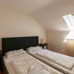 Schlafzimmer mit Doppelbett, zwei Nachttischen und Dachfenster.