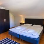 Schlafzimmer mit Doppelbett, zwei Nachttischen und einem Kleiderschrank.