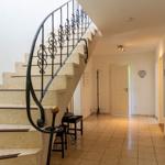 Haus mit geschwungener Treppe und Fliesenboden im Eingangsbereich.