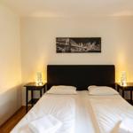 Schlafzimmer mit Doppelbett, zwei Nachttischen und Wandbildern.