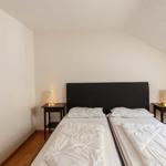 Zimmer mit Doppelbett, zwei Nachttischen und einer Wanddekoration.