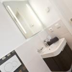 Badezimmer mit Waschbecken, Spiegel und Toilette