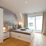 Schlafzimmer mit Bett, Schrank und Fenster zur Aussicht.