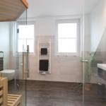 Badezimmer mit Sauna, Dusche, Toilette und Waschbecken